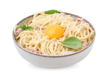 Bowl of tasty pasta Carbonara with basil leaves and egg yolk isolated on white