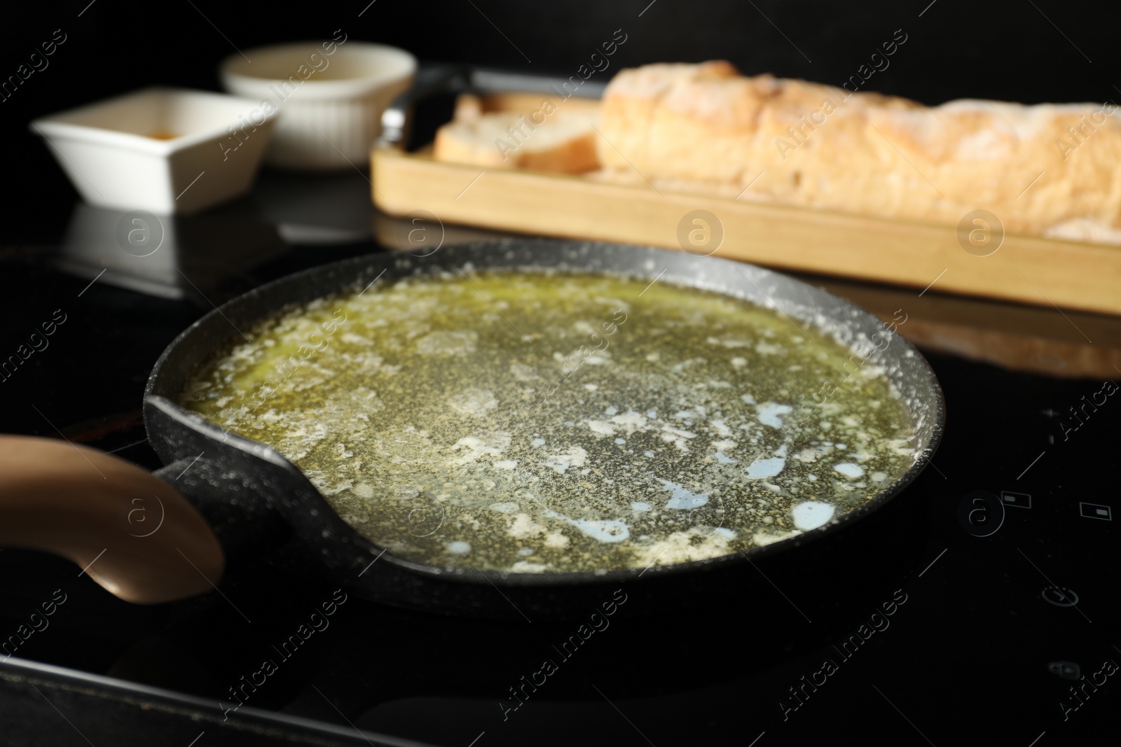 Photo of Melted butter in frying pan on cooktop, closeup