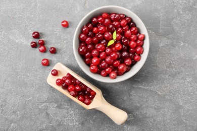 Photo of Fresh ripe cranberries in bowl and scoop on grey table, flat lay