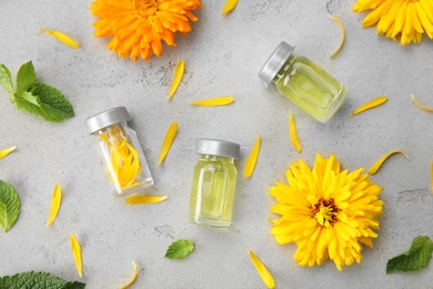 Flat lay composition with essential oils and ingredients on grey background