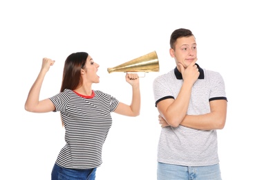 Young woman with megaphone shouting at man on white background