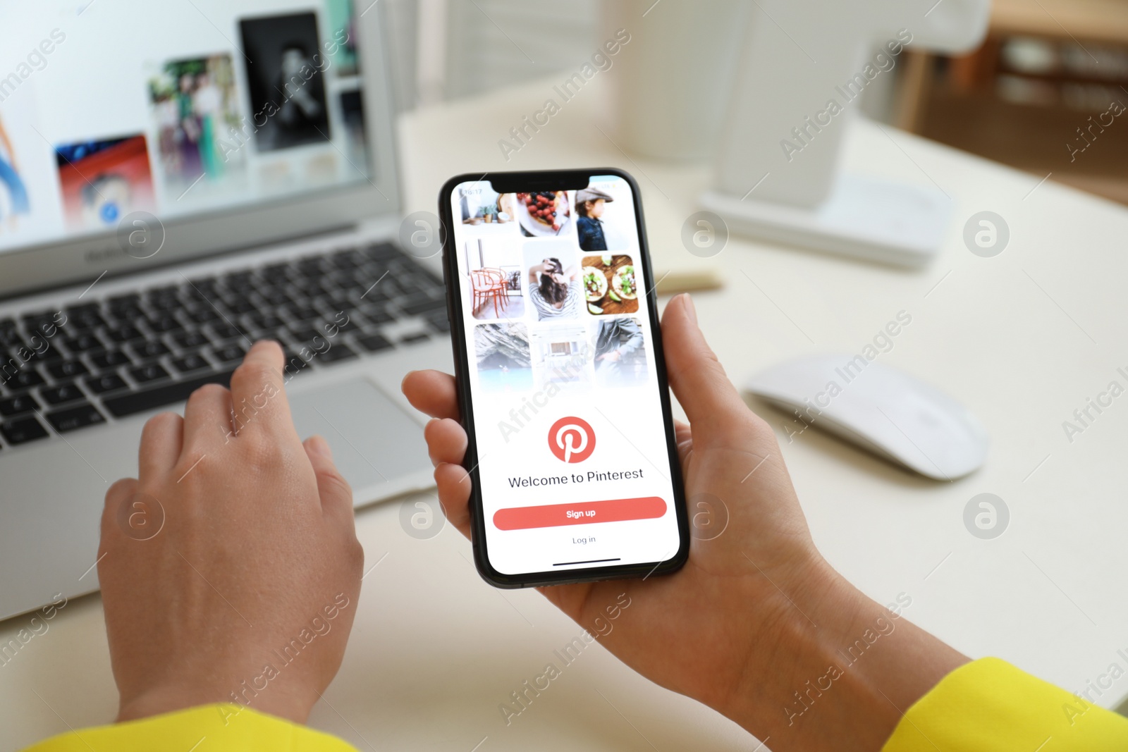 Photo of MYKOLAIV, UKRAINE - AUGUST 28, 2020: Woman holding iPhone 11 with Pinterest app on screen at table, closeup