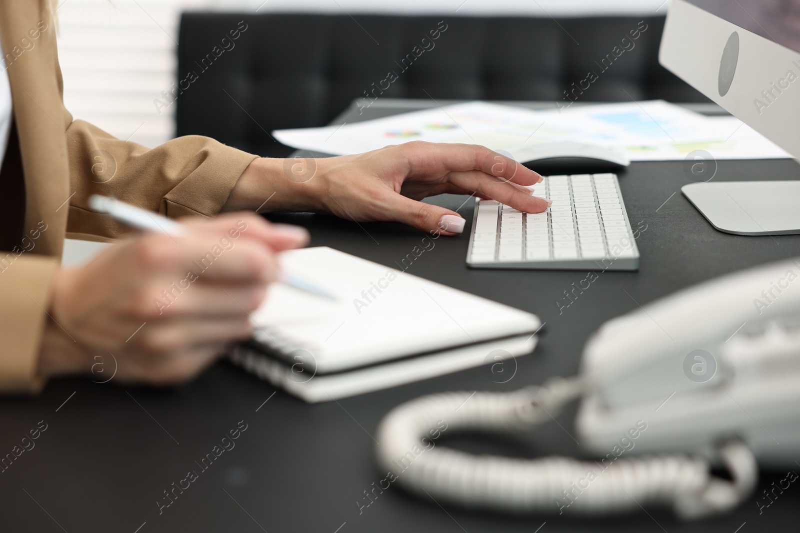 Photo of Secretary taking notes at table in office, closeup
