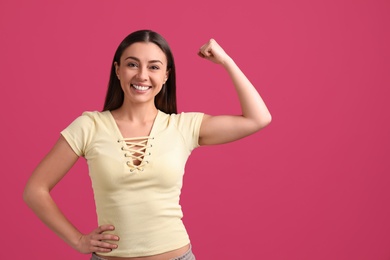 Photo of Strong woman as symbol of girl power on pink background, space for text. 8 March concept