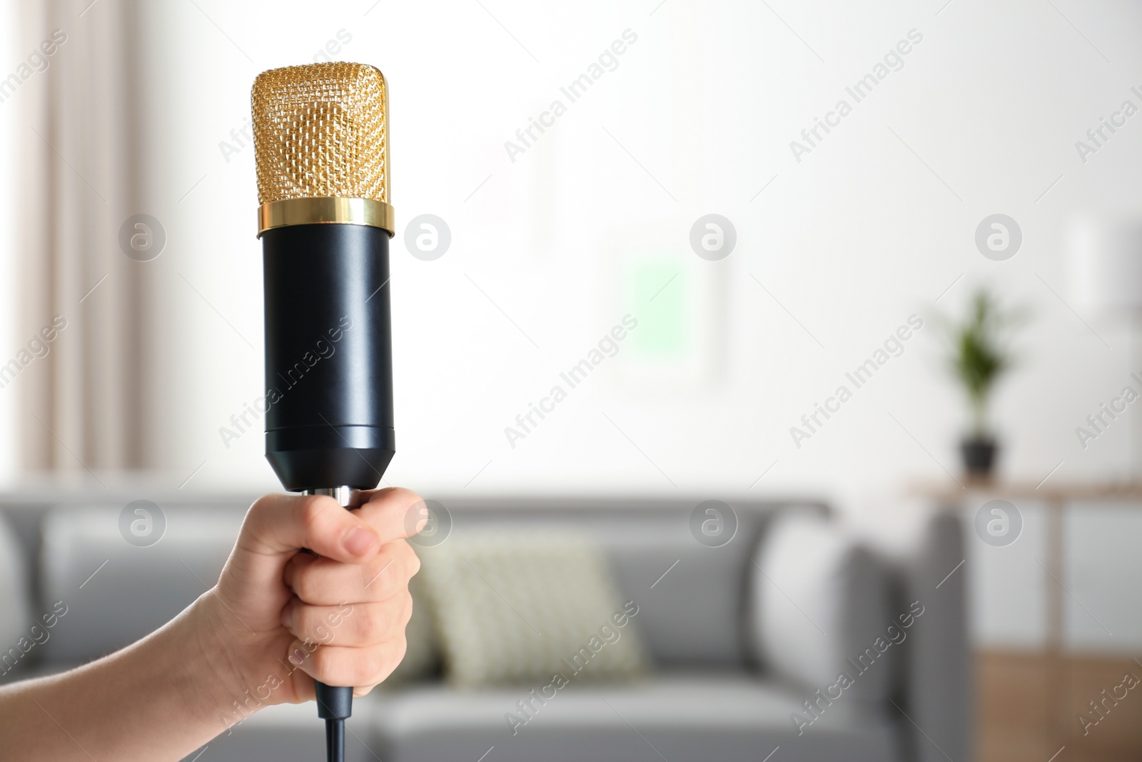 Photo of Child holding microphone on blurred background, closeup. Space for text