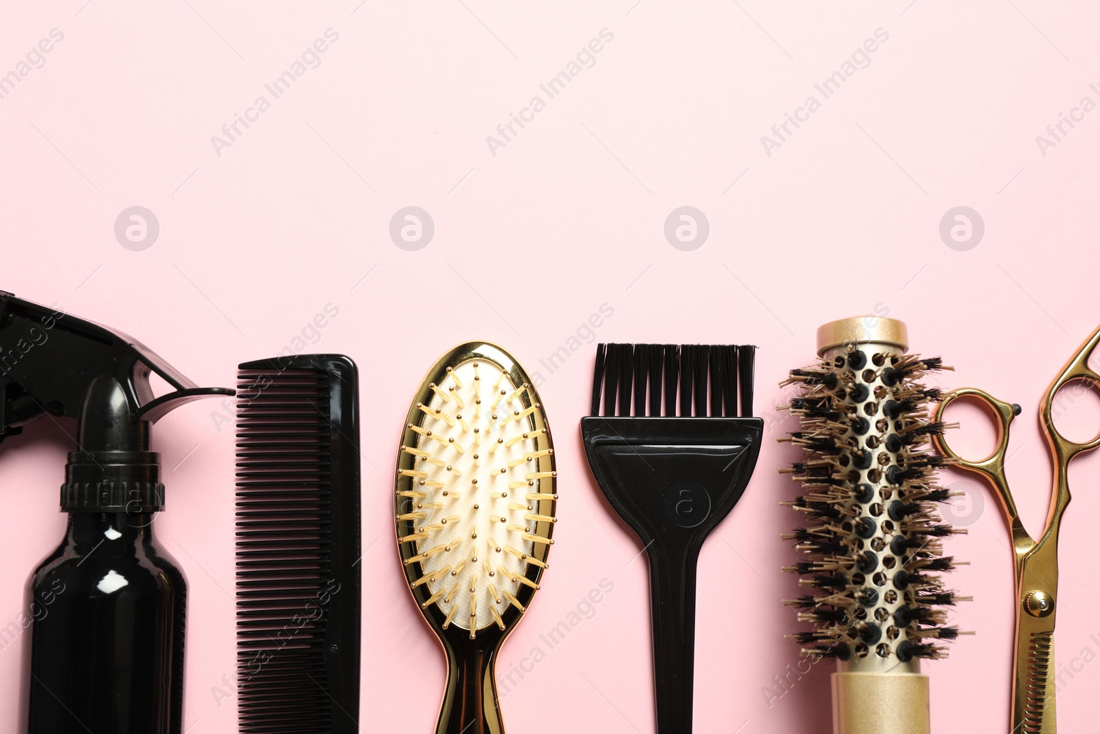 Photo of Professional hair dresser tools on pink background, flat lay. Space for text