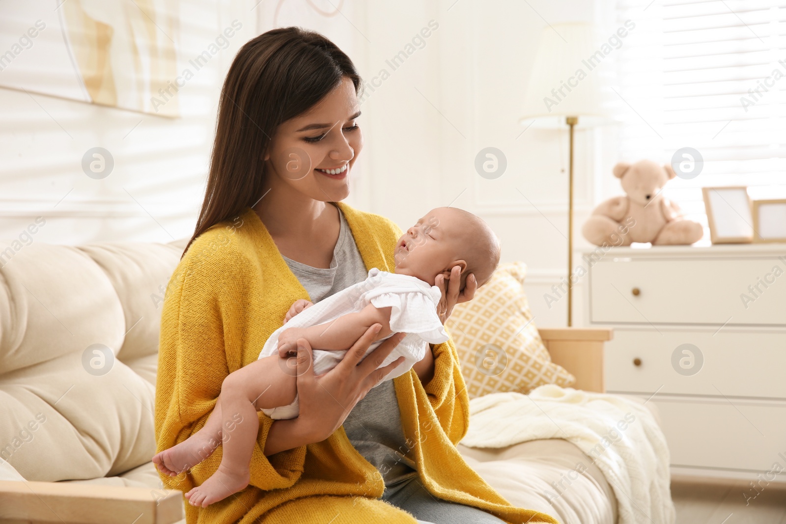 Photo of Mother holding her sleeping baby at home