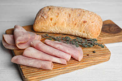 Photo of Slices of tasty ham on white wooden table