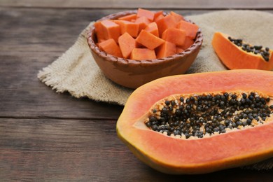 Photo of Tasty ripe cut papaya fruits on wooden table, closeup