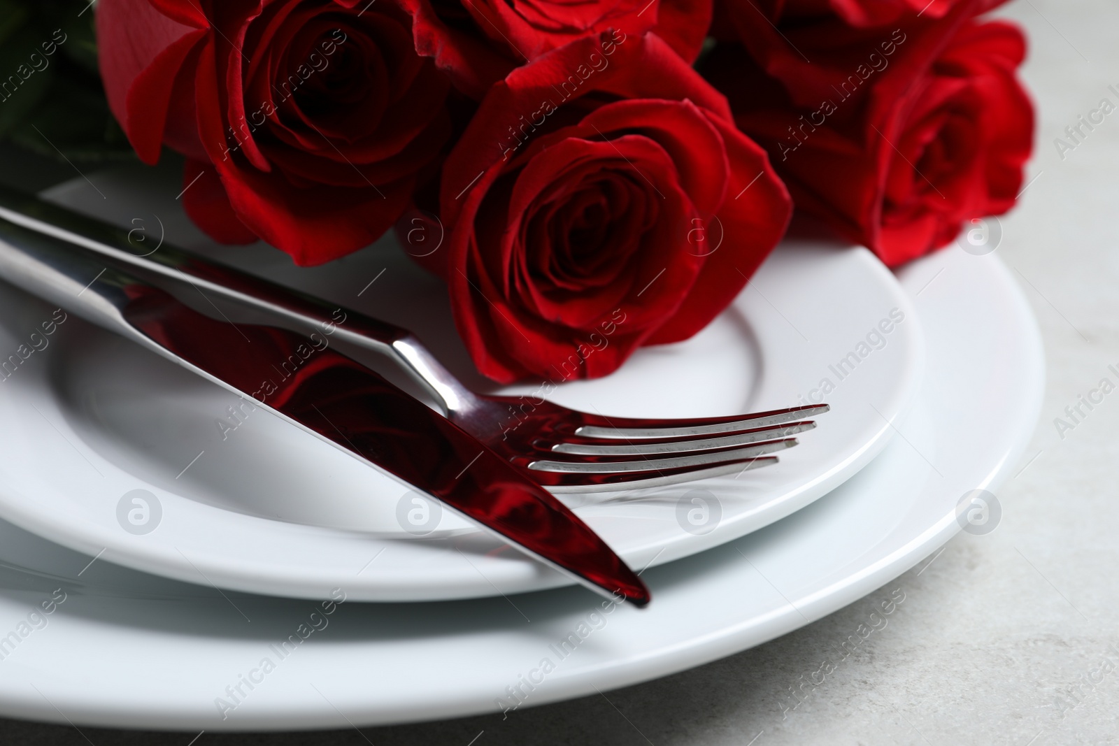 Photo of Romantic table setting with rose flowers, closeup