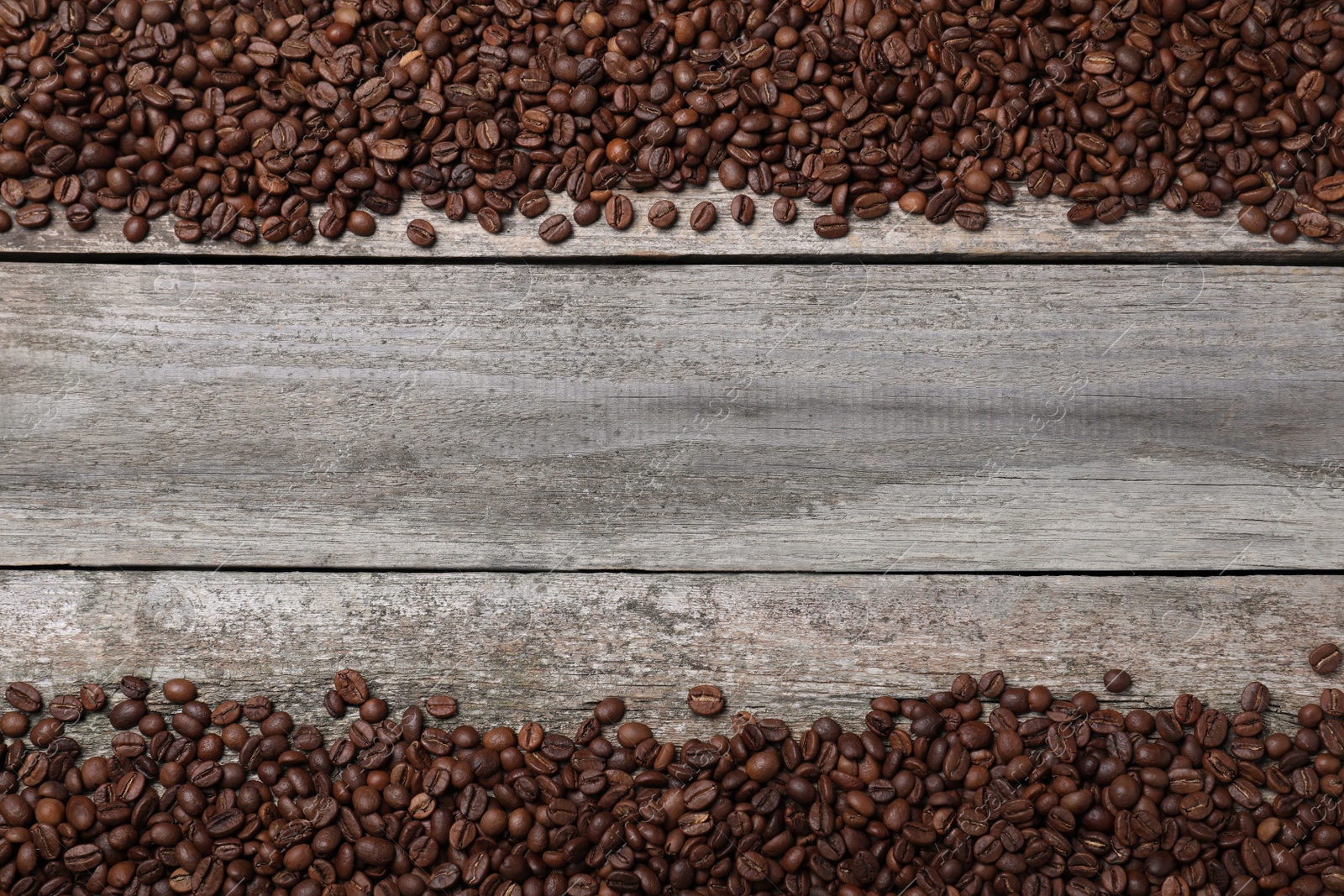 Photo of Roasted coffee beans on wooden table, flat lay. Space for text