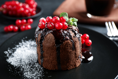 Delicious warm chocolate lava cake with mint and berries on plate, closeup