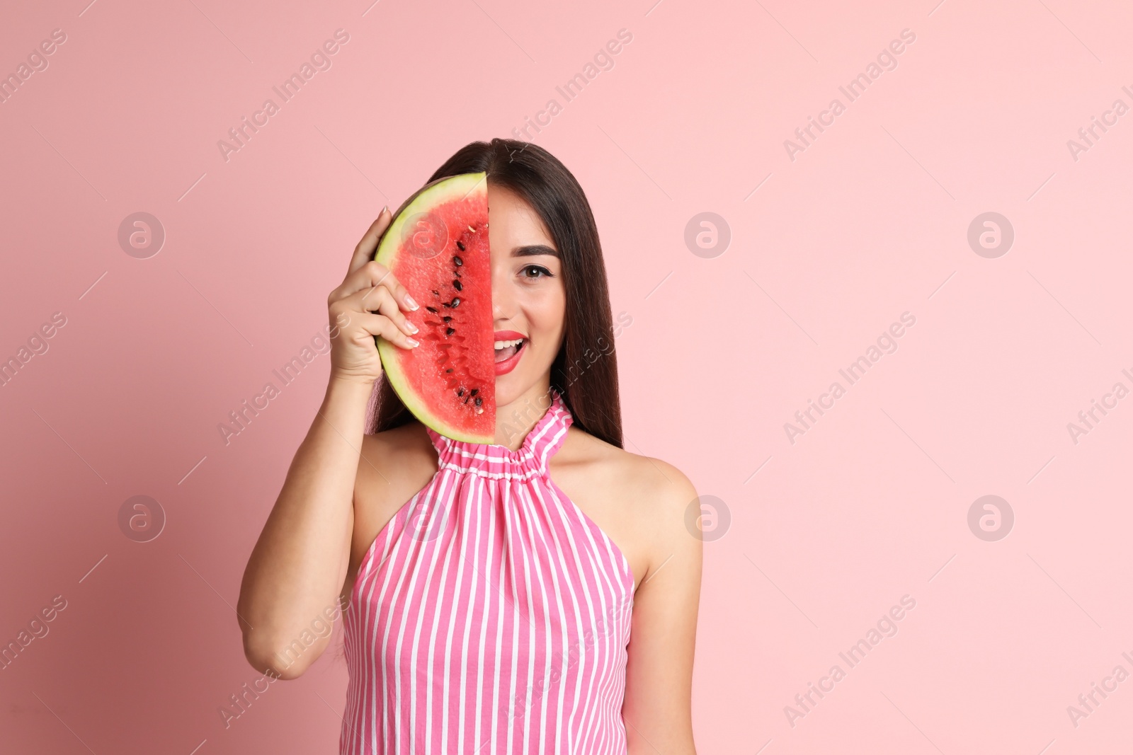 Photo of Beautiful young woman posing with watermelon on color background