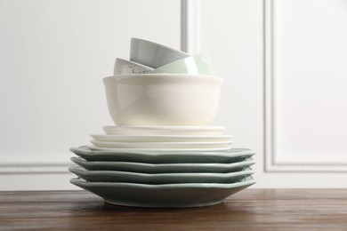 Photo of Stack of beautiful ceramic dishware on wooden table