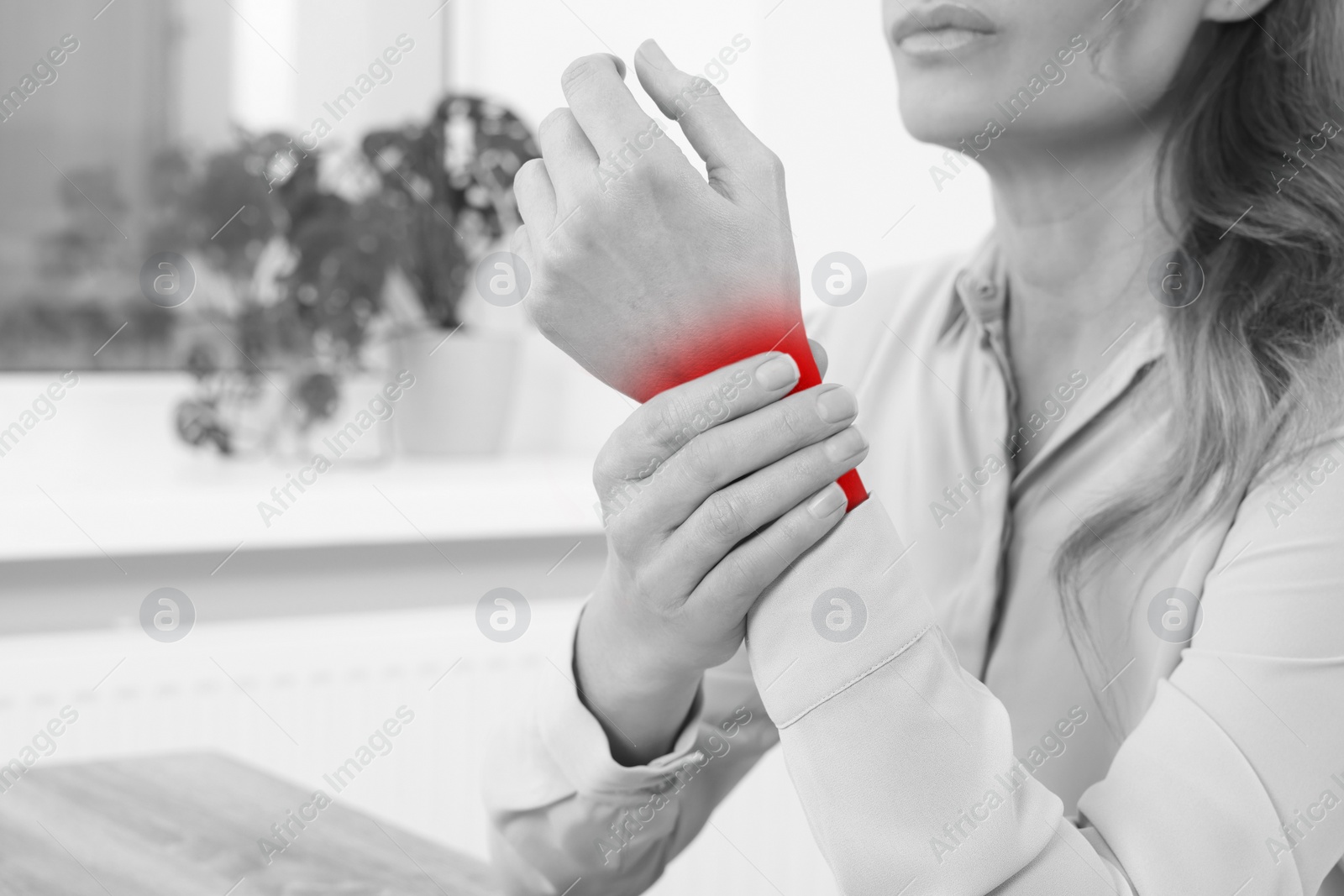 Image of Woman suffering from rheumatism at home, closeup. Black and white effect with red accent in painful area