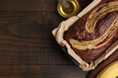 Photo of Delicious banana bread and honey on wooden table, top view. Space for text