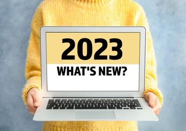 Image of Future trends. 2023 What's New? text on laptop display. Woman holding device, closeup