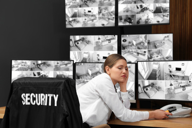 Tired security guard sleeping at workplace in office