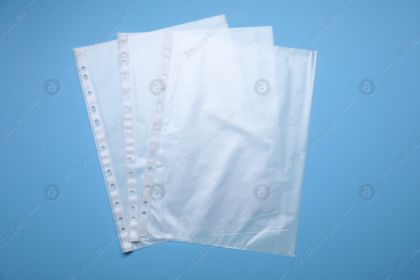 Photo of Punched pockets on light blue background, flat lay