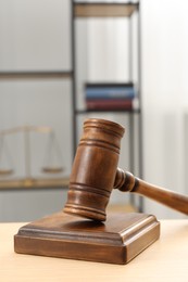 Photo of Wooden gavel and sound block on table indoors, closeup. Space for text