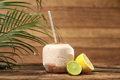 Photo of Open fresh coconut and citrus fruits on wooden table