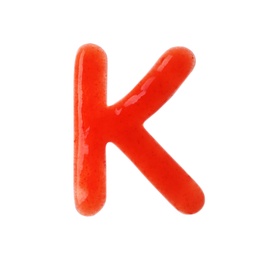 Letter K written with red sauce on white background