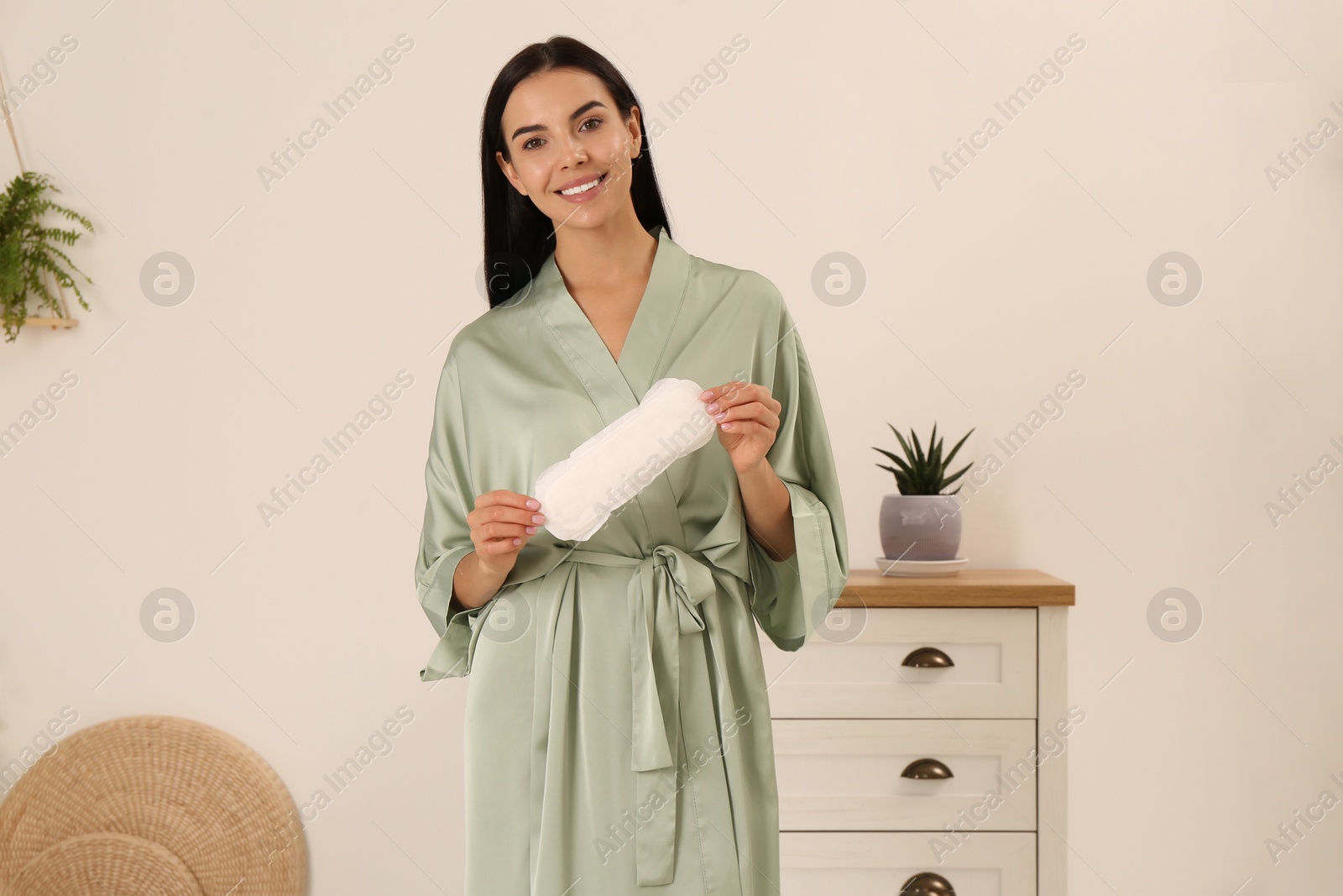 Photo of Young woman with menstrual pad at home