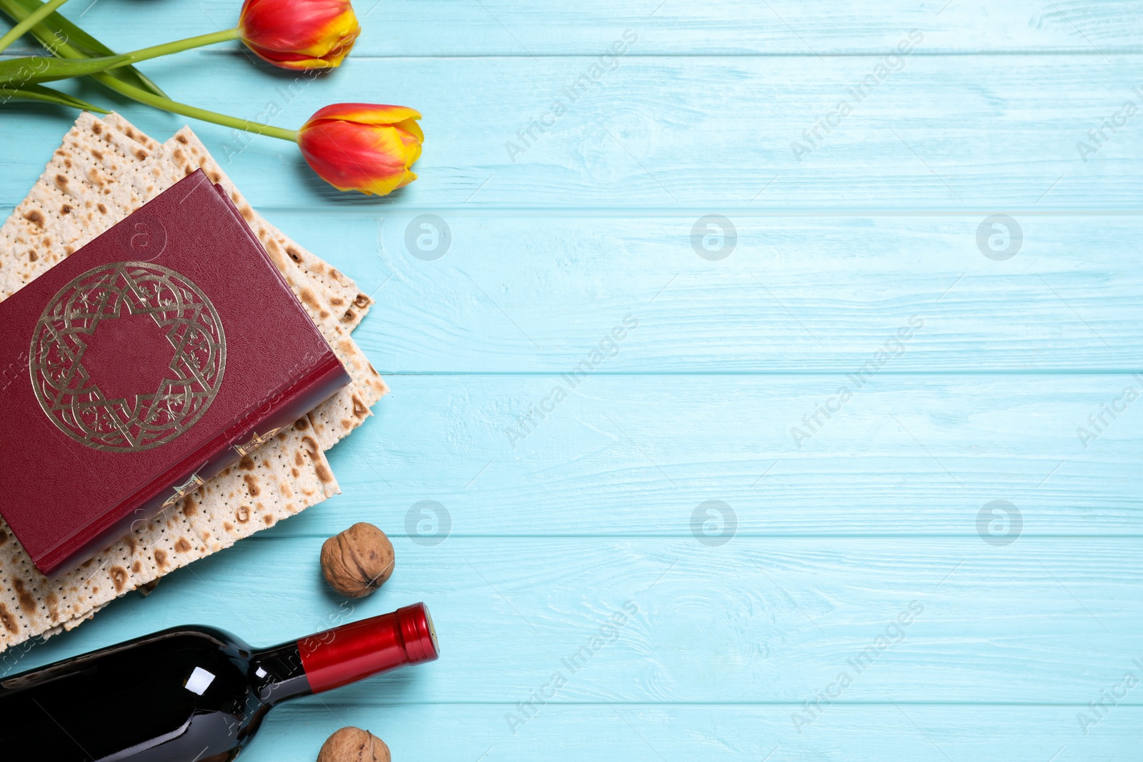 Photo of Flat lay composition with symbolic Pesach (Passover Seder) items on light blue wooden table, space for text