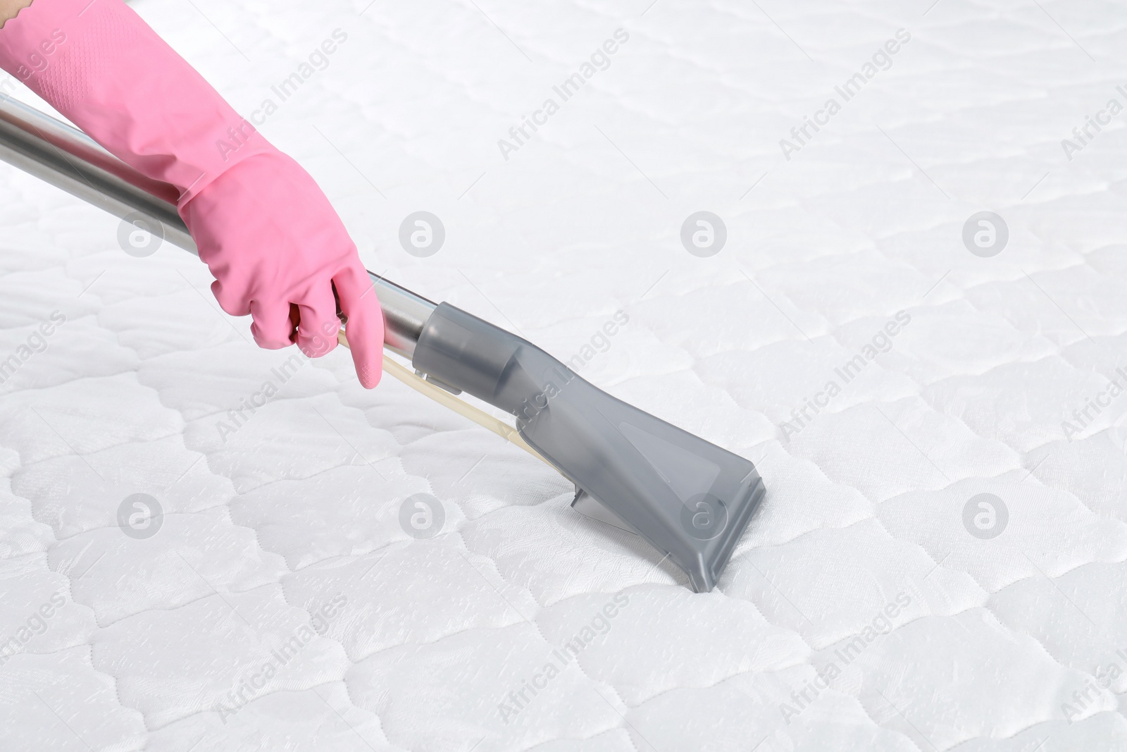 Photo of Person disinfecting mattress with vacuum cleaner, closeup. Space for text