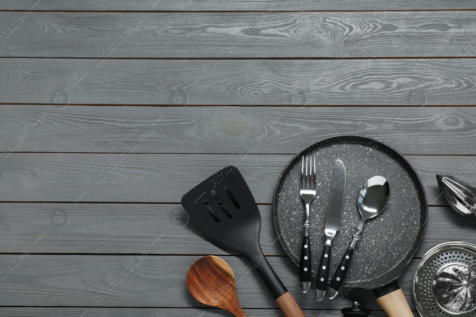 Photo of Set of kitchen utensils on dark grey wooden table, flat lay. Space for text