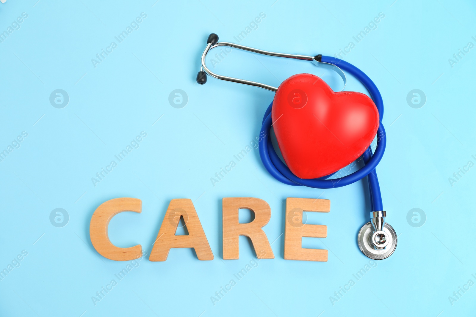 Photo of Flat lay composition with red heart, stethoscope and word CARE on color background