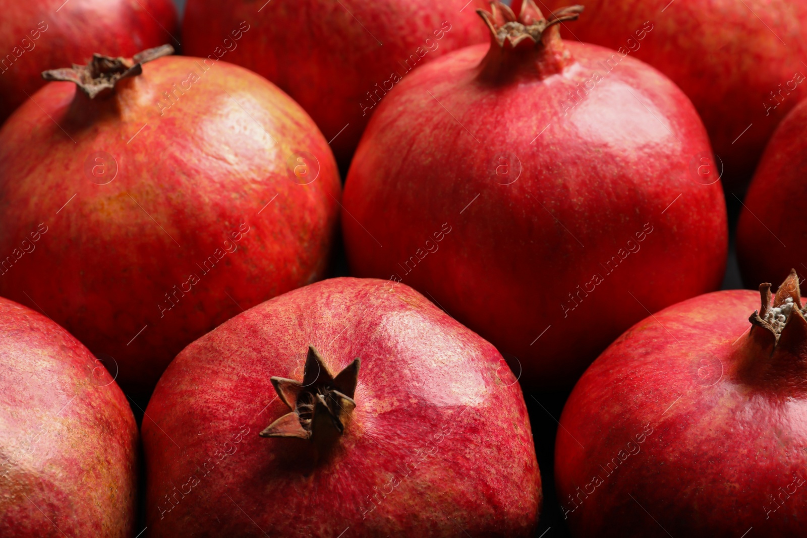 Photo of Many red ripe pomegranate fruits as background