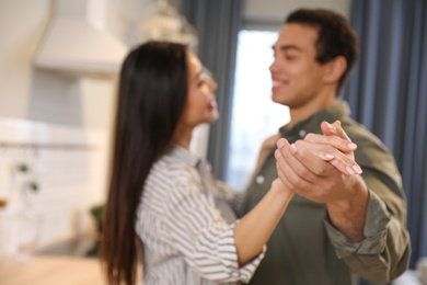 Photo of Lovely young interracial couple dancing at home, focus on hands