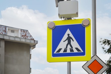 Traffic sign Pedestrian Crossing and Main road against sky outdoors