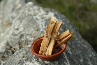 Many palo santo sticks on stone surface outdoors