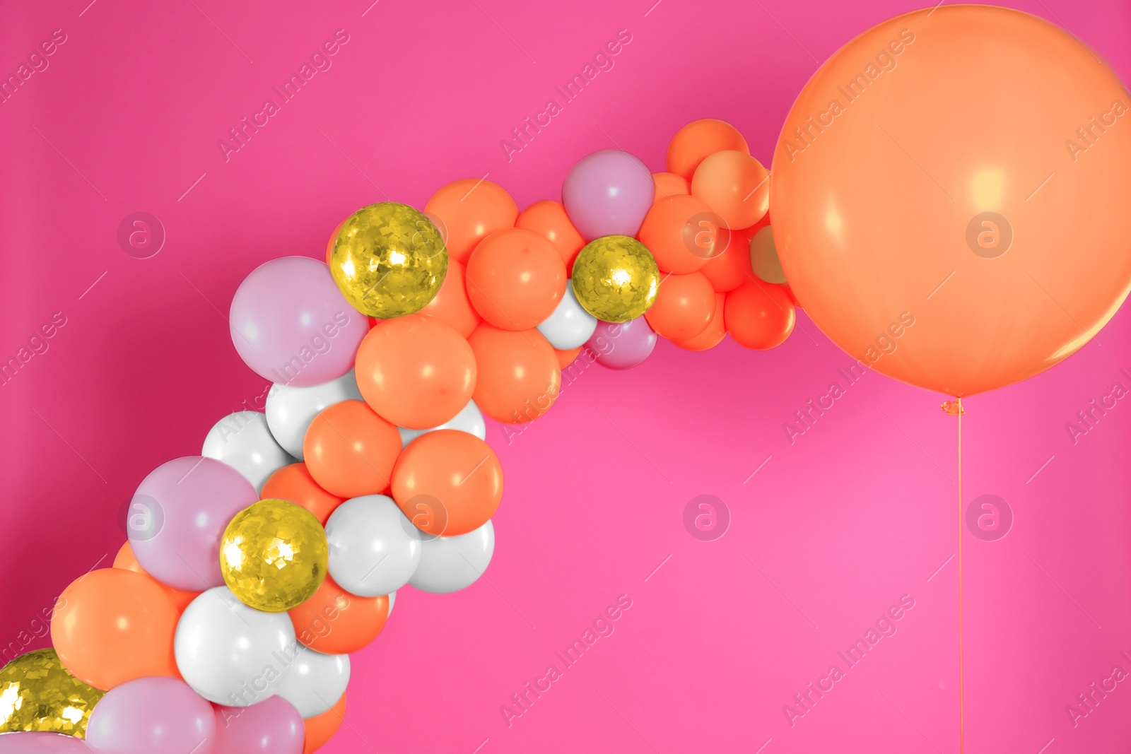 Image of Balloon garland on pink background. Festive decor