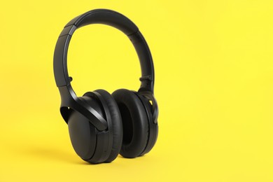 Photo of Modern wireless headphones on color background. Space for text