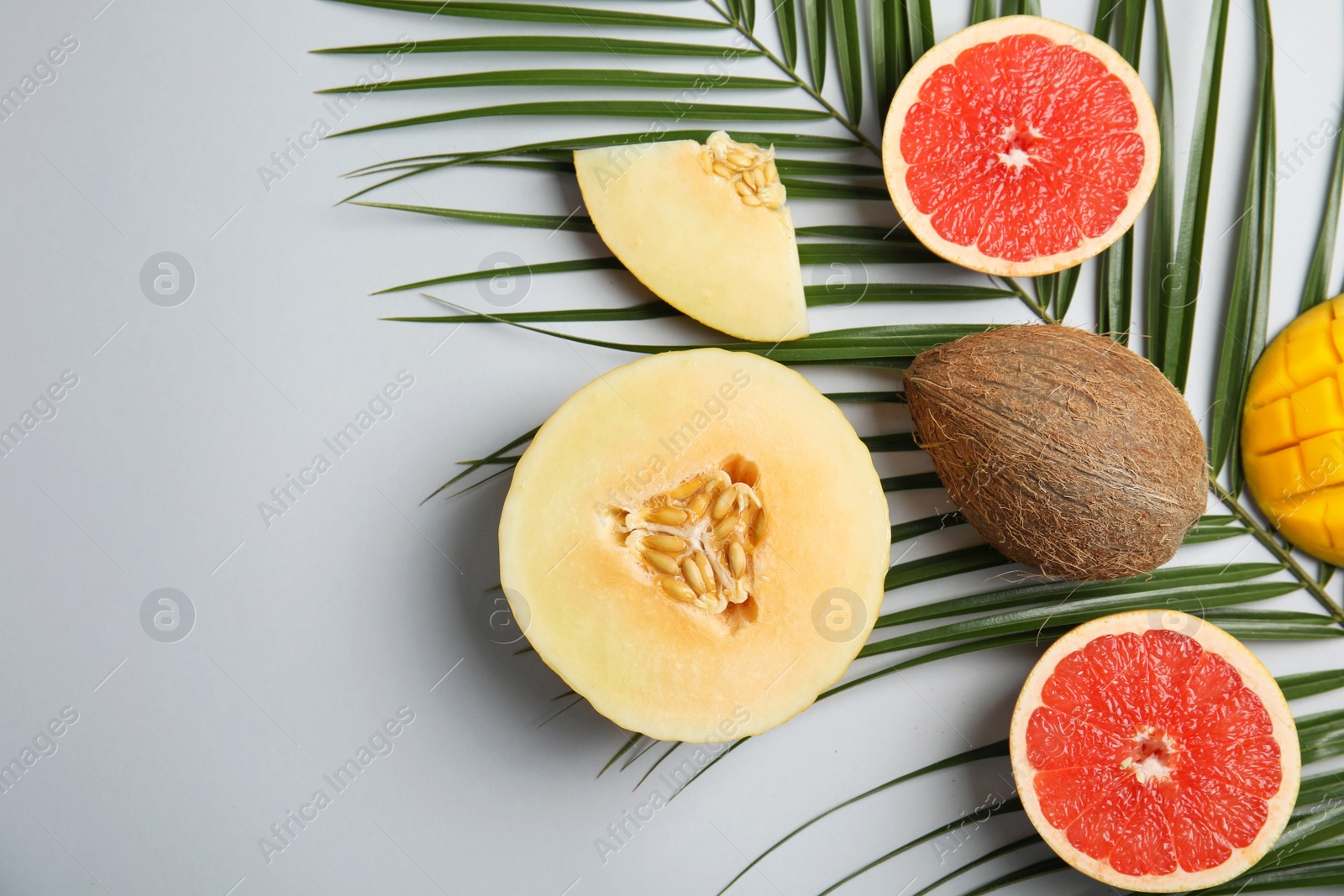 Photo of Flat lay composition with melon, other fruits and space for text on color background