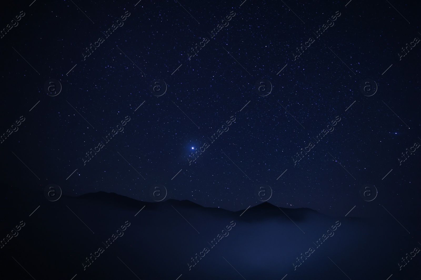 Photo of Beautiful view of misty mountains under starry sky at night