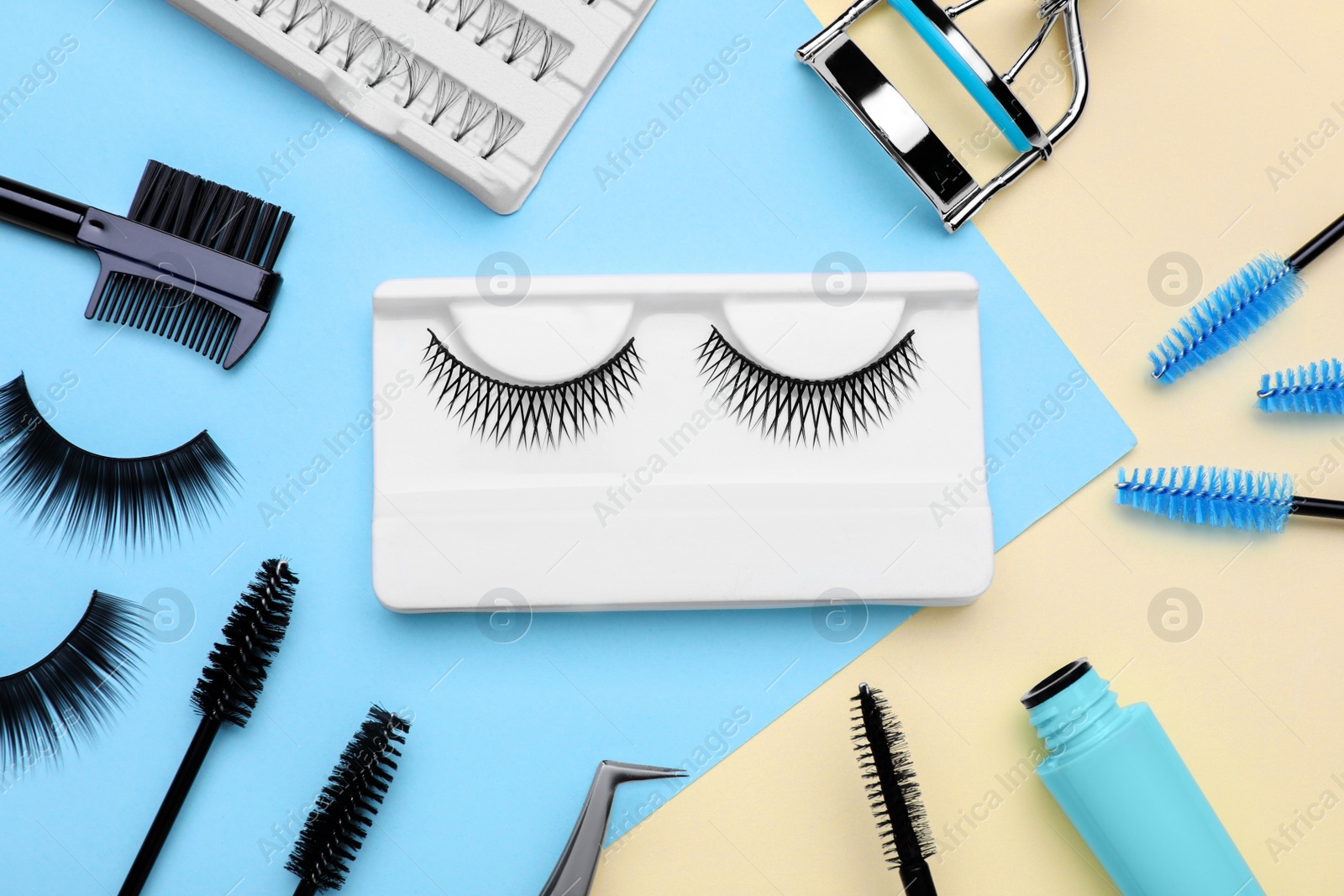 Photo of Flat lay composition with fake eyelashes, brushes and tools on color background