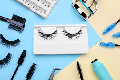 Flat lay composition with fake eyelashes, brushes and tools on color background