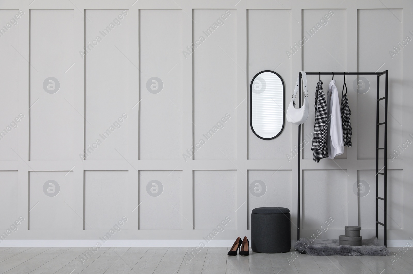 Photo of Simple hallway interior with clothing rack, mirror and empty wall. Space for design
