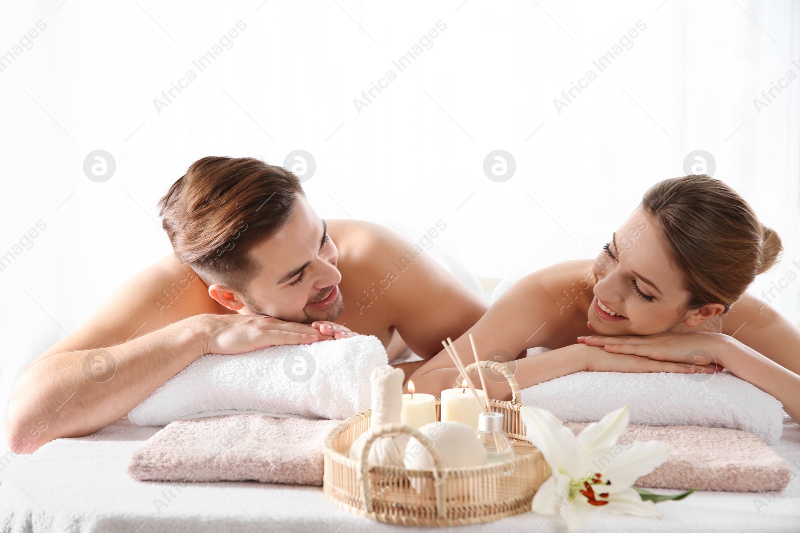 Photo of Young couple with spa essentials in wellness center