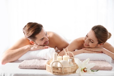 Young couple with spa essentials in wellness center