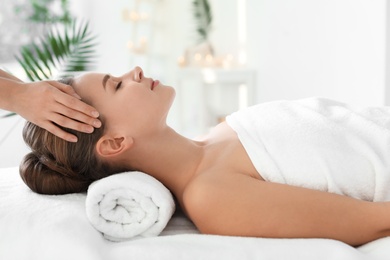 Young woman enjoying massage in spa salon