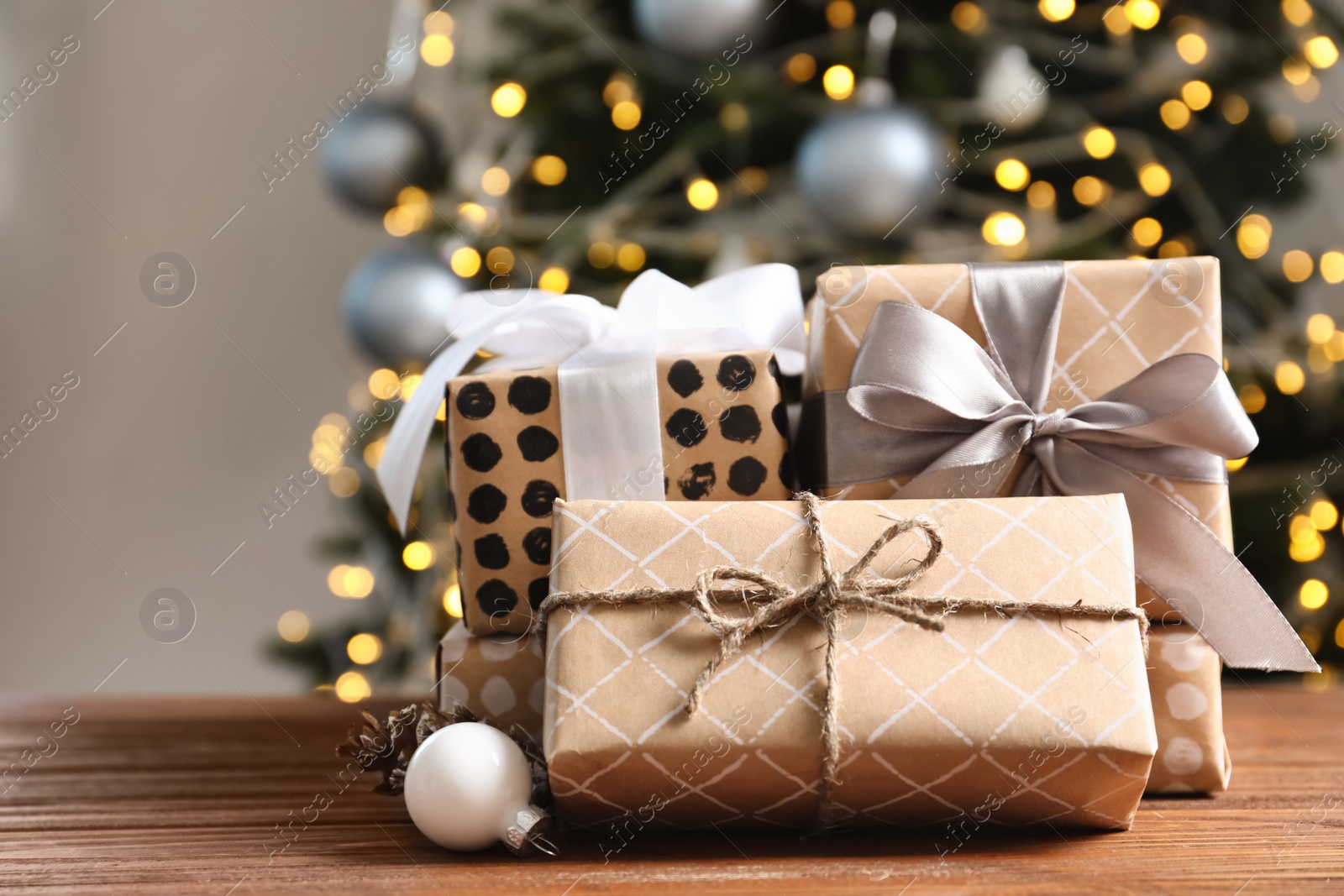 Photo of Beautiful gift boxes and blurred Christmas tree on background