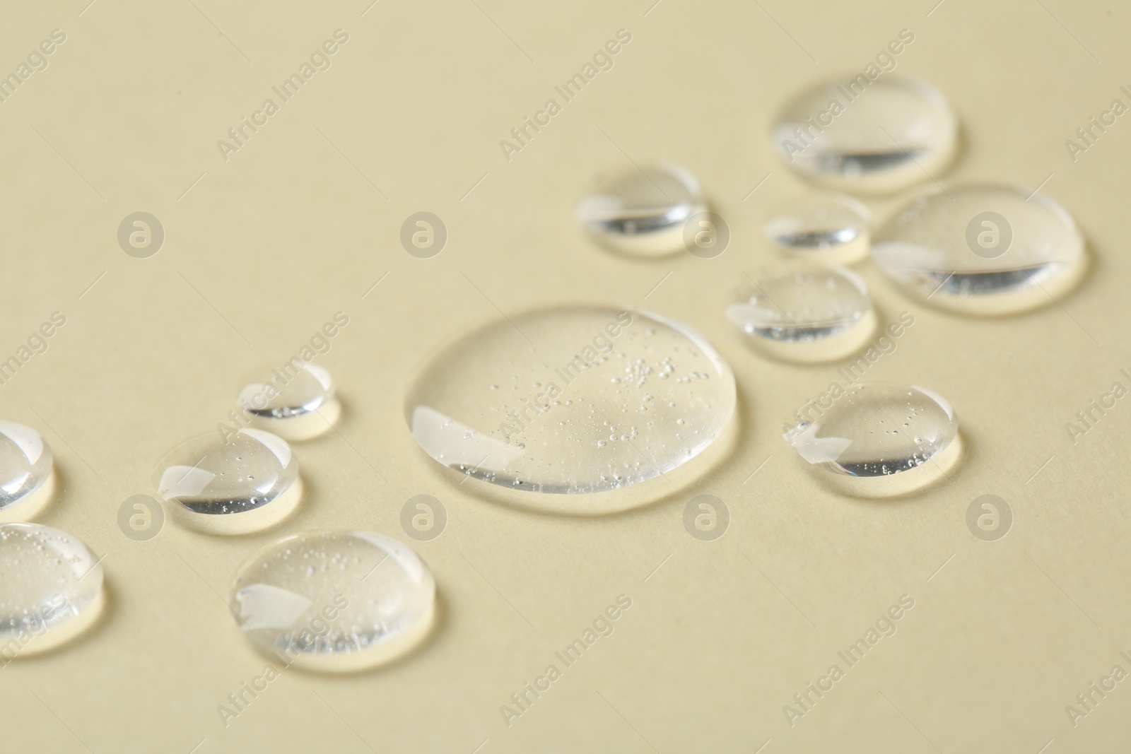 Photo of Samples of cosmetic serum on beige background, closeup