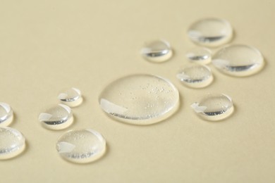 Samples of cosmetic serum on beige background, closeup