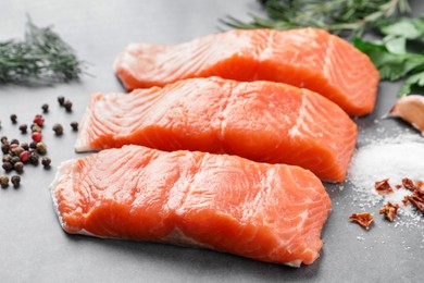 Photo of Fresh salmon and ingredients for marinade on grey table, closeup