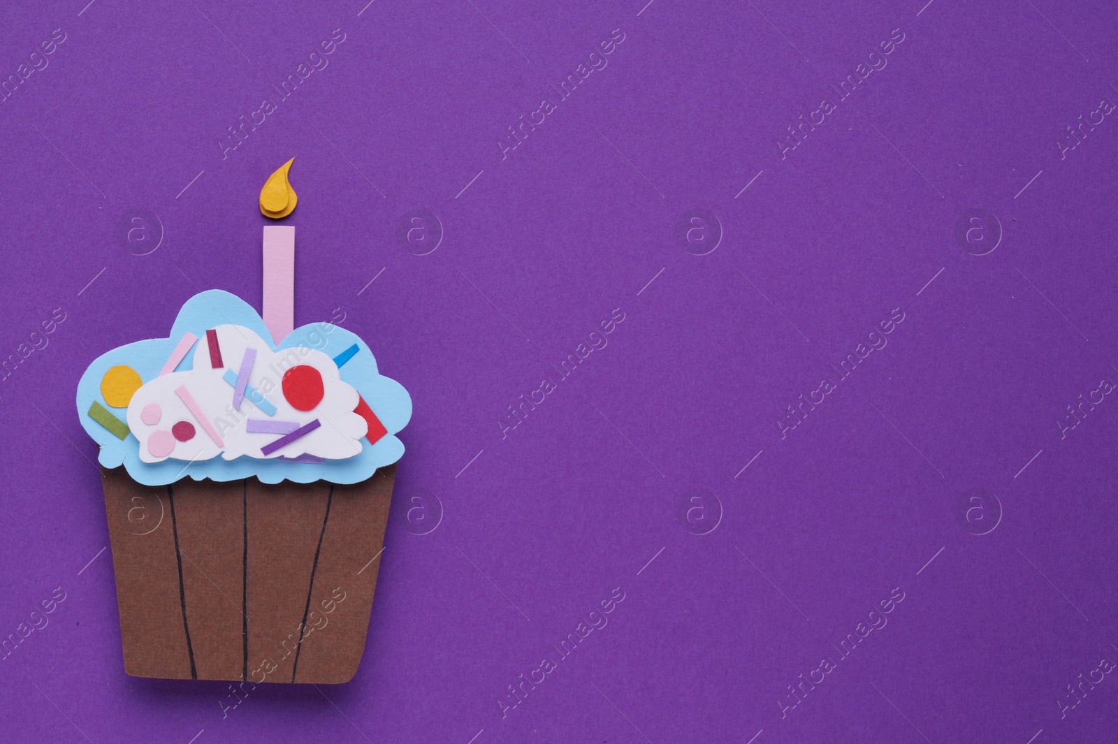 Photo of Birthday party. Paper cupcake on purple background, top view with space for text